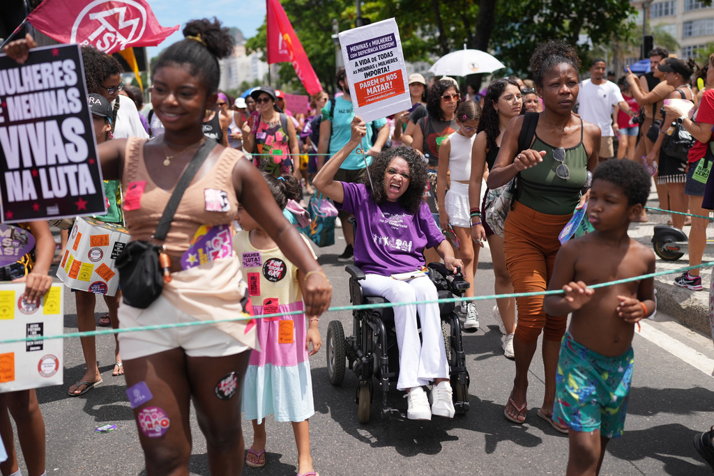 People march marking International Women's Day on Copacabana beach, in Rio de Janeiro, Sunday, March 8, 2026. (AP Photo/Silvia Izquierdo)