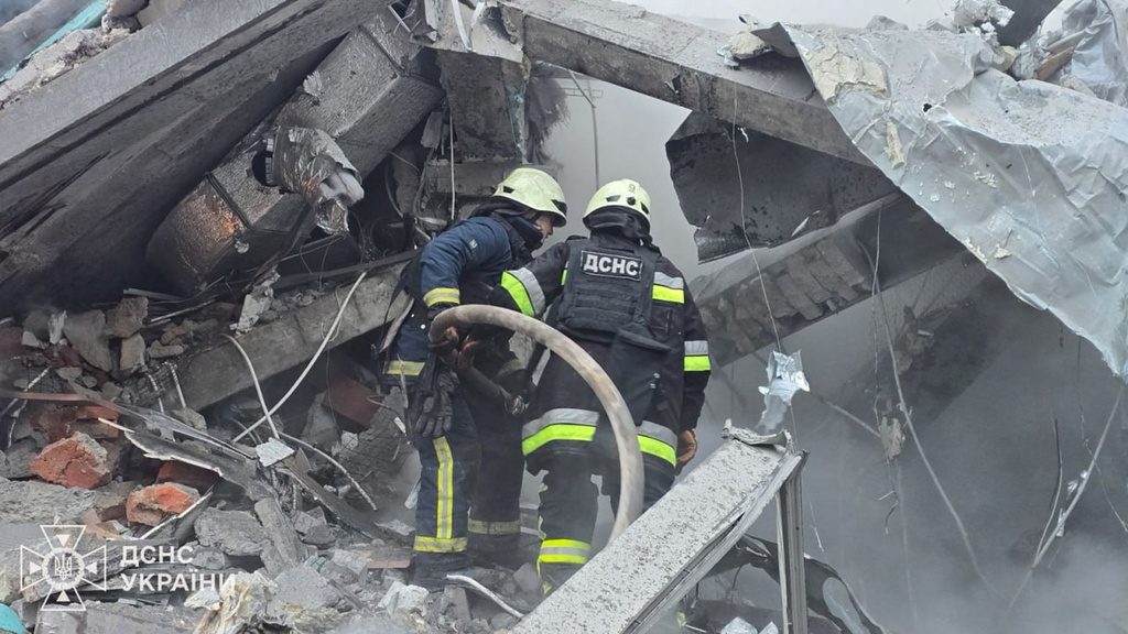 In this photo provided by the Ukrainian Emergency Service, emergency services personnel work to extinguish a fire following a Russian missile attack in Kharkiv, Ukraine, Friday, Jan. 2, 2026. (Ukrainian Emergency Service via AP)
