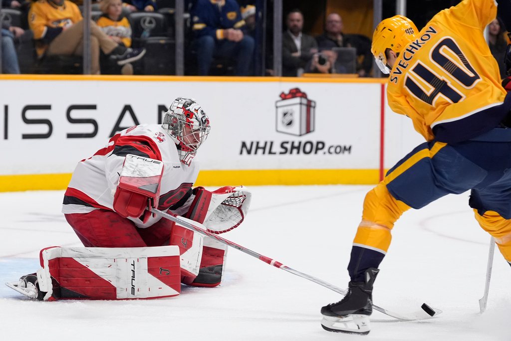 Carolina Hurricanes goaltender Pyotr Kochetkov (52) defends the goal against Nashville Predators center Fedor Svechkov (40) during the second period of an NHL hockey game Wednesday, Dec. 17, 2025, in Nashville, Tenn. (AP Photo/George Walker IV)