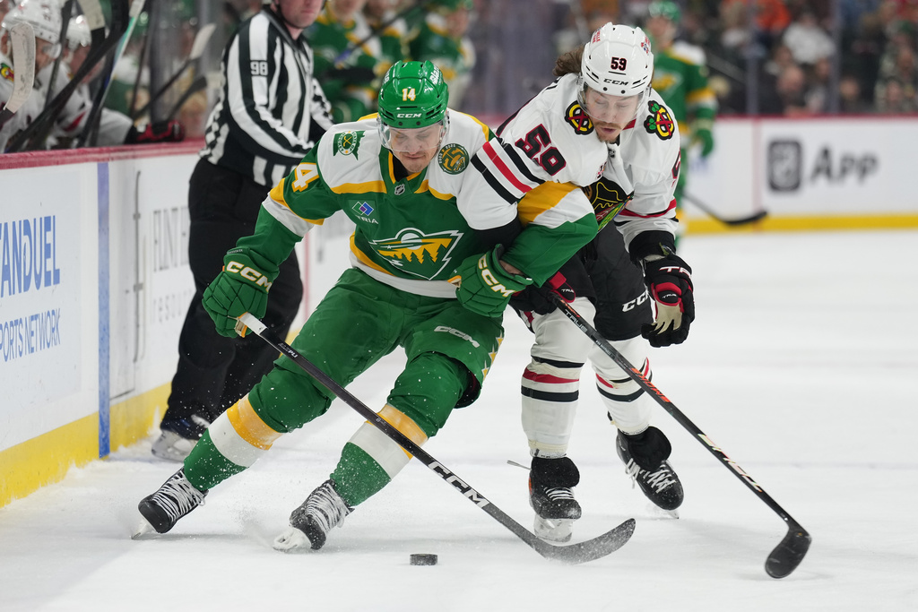 Minnesota Wild center Joel Eriksson Ek (14) and Chicago Blackhawks left wing Tyler Bertuzzi (59) battle for the puck during the first period of an NHL hockey game, Tuesday, Jan. 27, 2026, in St. Paul, Minn. (AP Photo/Abbie Parr)