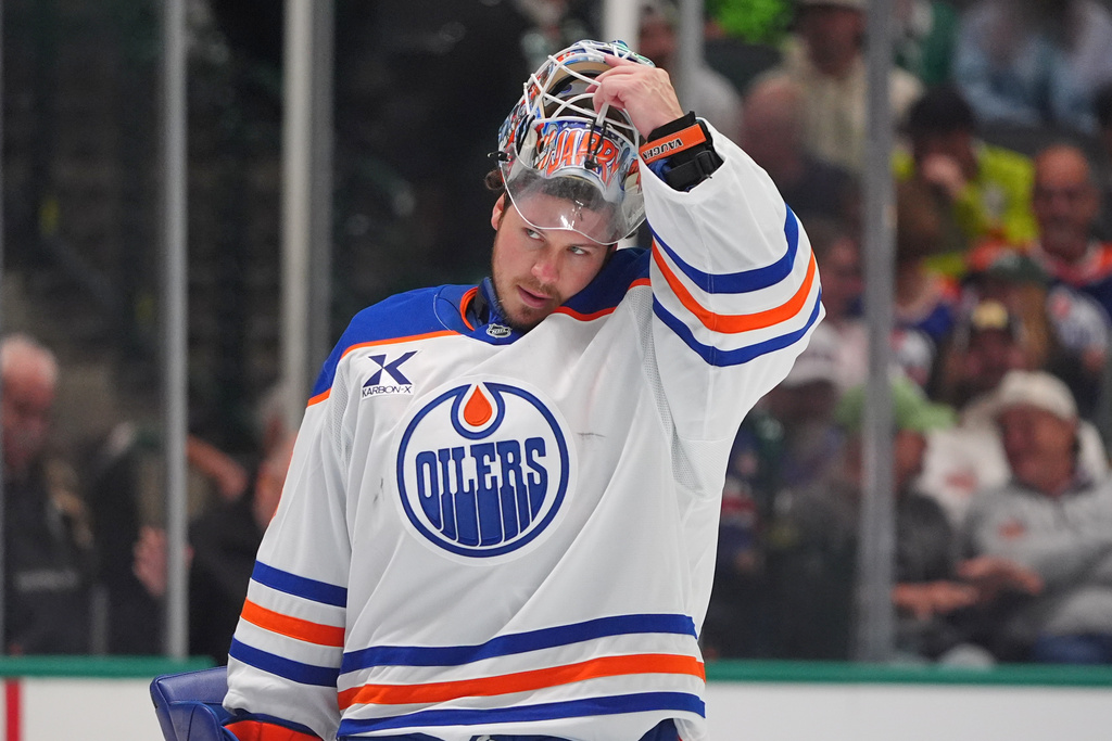 Edmonton Oilers goaltender Tristan Jarry lifts his helmet during the first period of an NHL hockey game against the Dallas Stars, Thursday, March 12, 2026, in Dallas. (AP Photo/LM Otero)