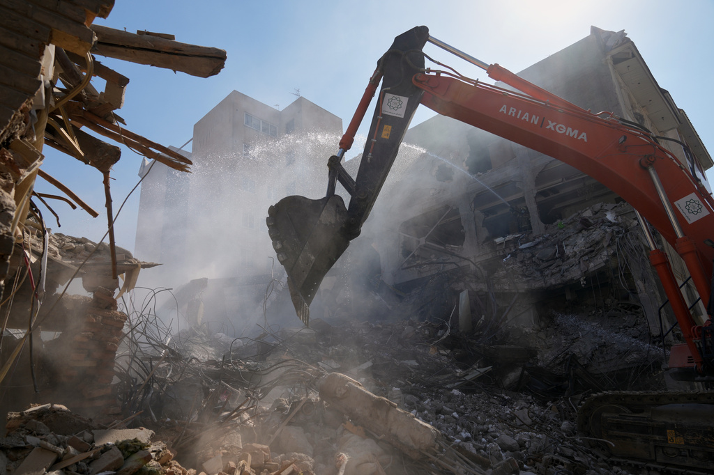 An excavator removes rubble at the site of a strike that, according to a security official at the scene, destroyed half of the Khorasaniha Synagogue and nearby residential buildings in Tehran, Iran, Tuesday, April 7, 2026. (AP Photo/Francisco Seco)