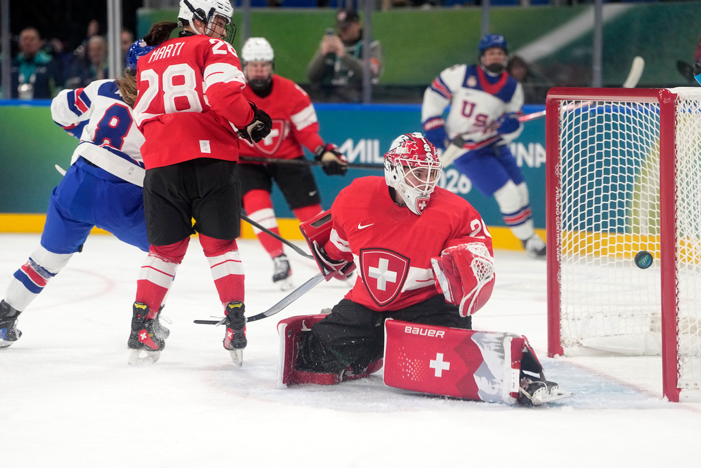 United States' Haley Winn, left, scores her side's opening goal during a preliminary round match of women's ice hockey between Switzerland and United States at the 2026 Winter Olympics, in Milan, Italy, Monday, Feb. 9, 2026. (AP Photo/Hassan Ammar)