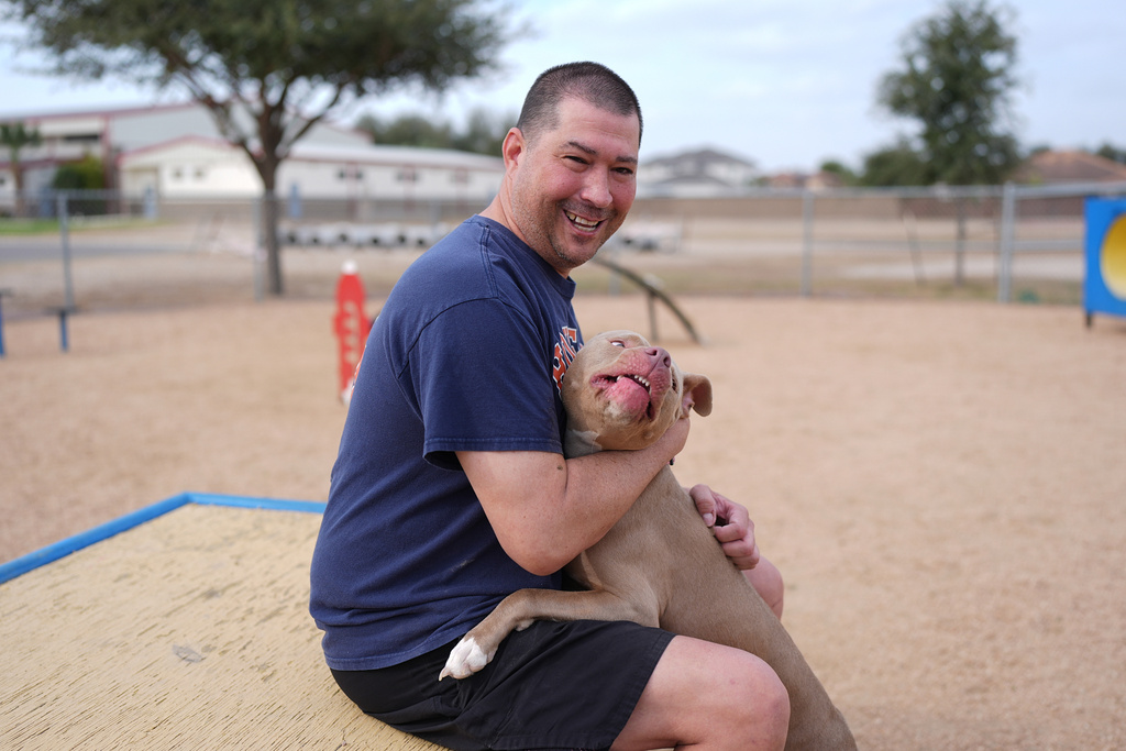 Ryan Vannest, 53, a retired high school teacher, spends time with his dog Ella at a dog park in Mission, Texas, Tuesday, Feb. 10, 2026. (AP Photo/Eric Gay)