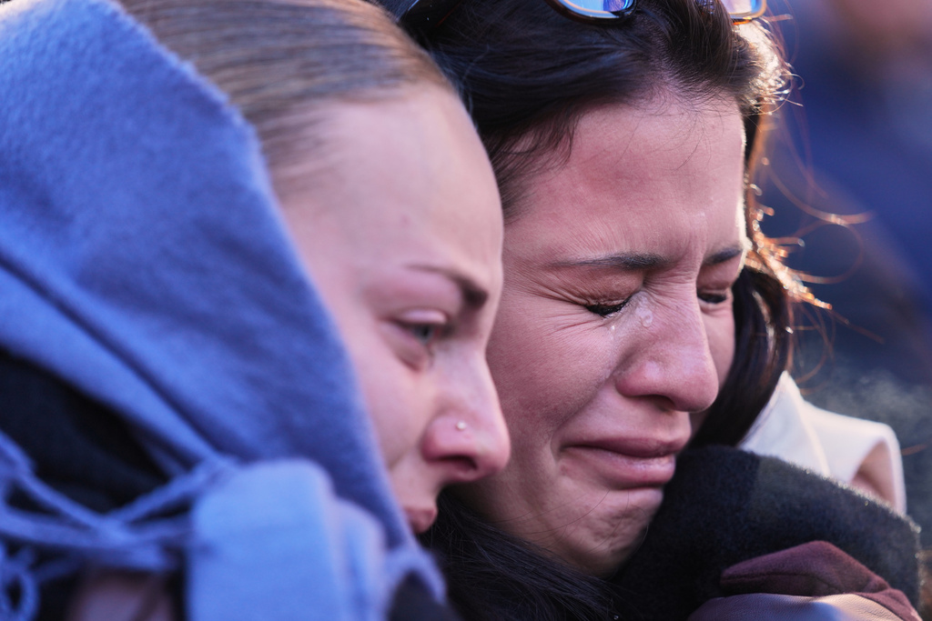People mourn during a memorial procession in Crans-Montana, Swiss Alps, Switzerland, Sunday, Jan. 4, 2026, after a devastating fire in Le Constellation bar left dead and injured during the New Year's celebrations. (AP Photo/ Antonio Calanni)