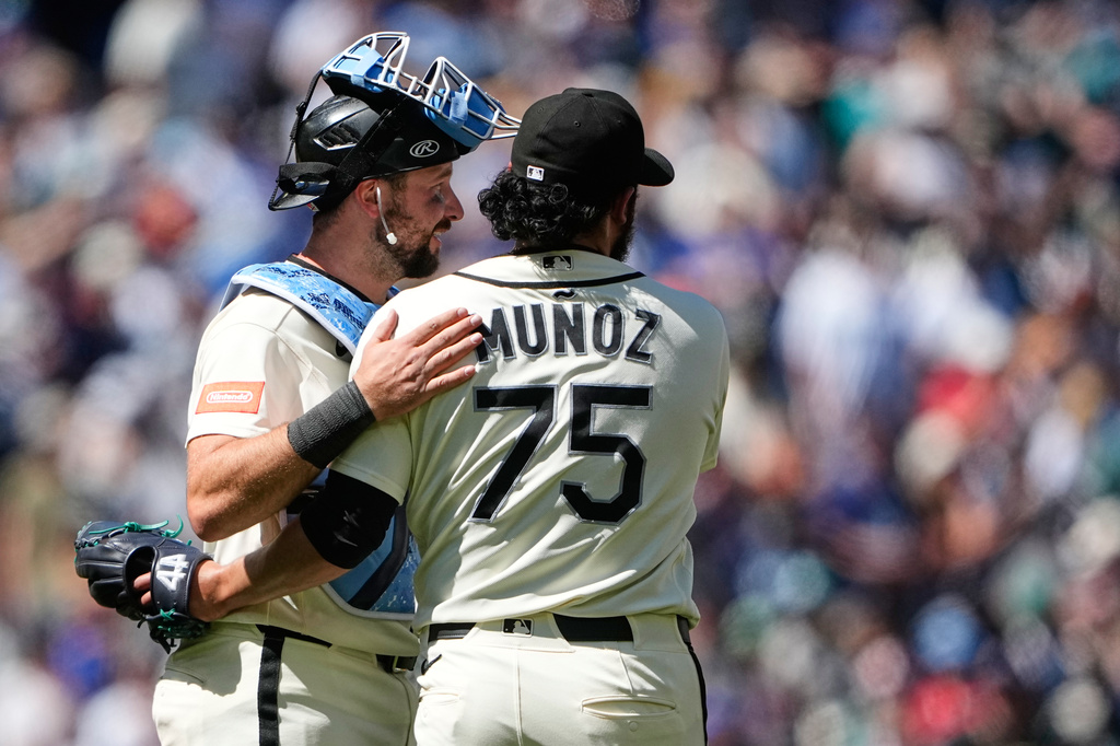Seattle Mariners catcher Cal Raleigh greets relief pitcher Andrés Muñoz as they celebrate a win over the Boston Red Sox in a baseball game, Sunday, June 21, 2026, in Seattle. (AP Photo/Lindsey Wasson)