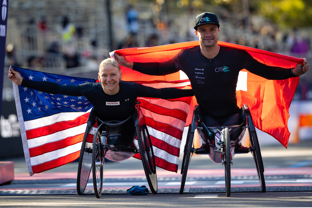 Susannah Scaroni of the United States and Marcel Hug of Switzerland celebrate winning first place in the women's and men's wheelchair divisions of the New York City Marathon, Sunday, Nov. 2, 2025, in New York. (AP Photo/Angelina Katsanis)
