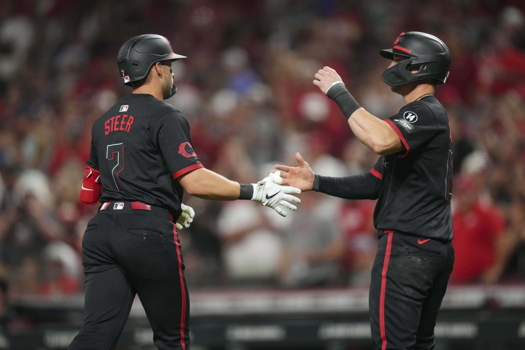 Cincinnati Reds' Spencer Steer (7) celebrates with teammate Austin Hays after hitting a two-run home run during the sixth inning of a baseball game against the Chicago Cubs, Friday, Sept. 19, 2025, in Cincinnati. (AP Photo/Jeff Dean)