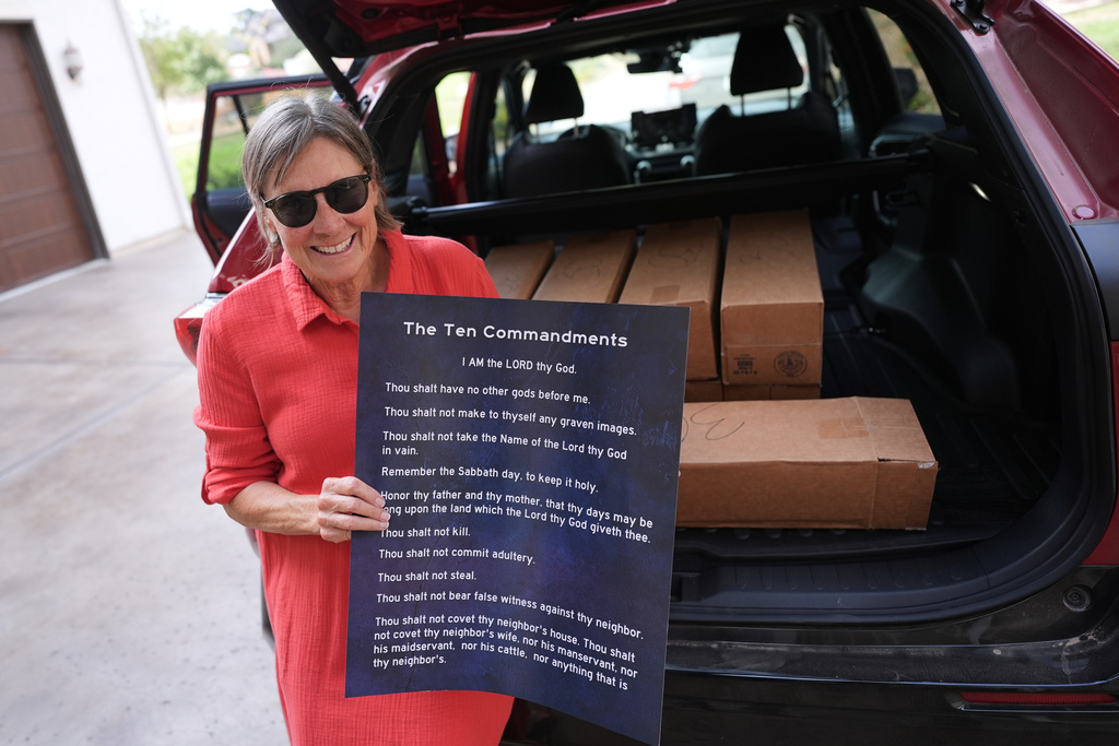 Debbie Leimback displays one of the hundreds of Ten Commandments posters she was preparing to deliver to local public schools in New Braunfels, Texas, Monday, Nov. 17, 2025. (AP Photo/Eric Gay)