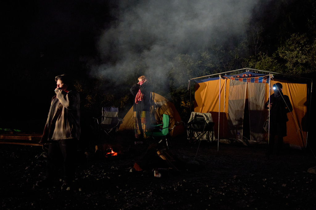 Land defenders gather on a logging road before dawn as a logging vehicle approaches the blockade near Port Renfrew, British Columbia, Thursday, May 28, 2026. (AP Photo/Annika Hammerschlag)