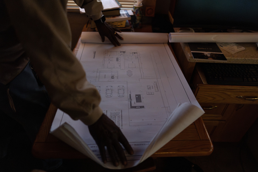 Ellaird Bailey, who lives in an RV on the property where his home was destroyed by the Eaton Fire, looks at building plans, Friday, Dec. 12, 2025, in Altadena, Calif. (AP Photo/Jae C. Hong)