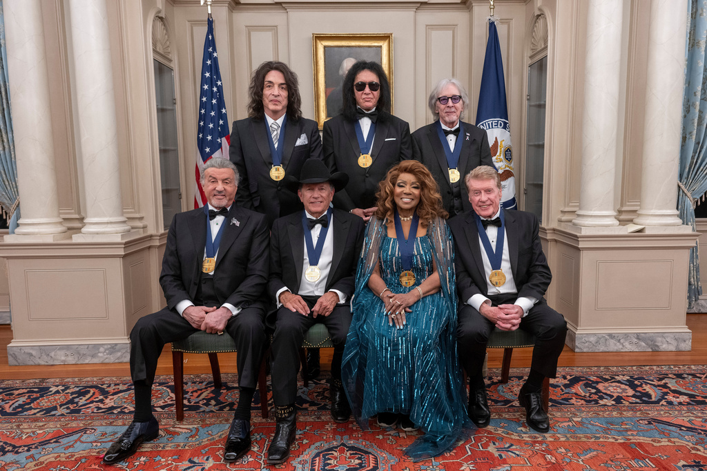 The 2025 Kennedy Center Honorees, front row from left, Sylvester Stallone, George Strait, Gloria Gaynor and Michael Crawford; back row from left, members of the rock band KISS, Paul Stanley, Gene Simmons and Peter Criss, pose for a group photo at the 48th Kennedy Center Honors Medallion Reception, hosted at the U.S. Department of State, Saturday, Dec. 6, 2025 in Washington. (AP Photo/Kevin Wolf)