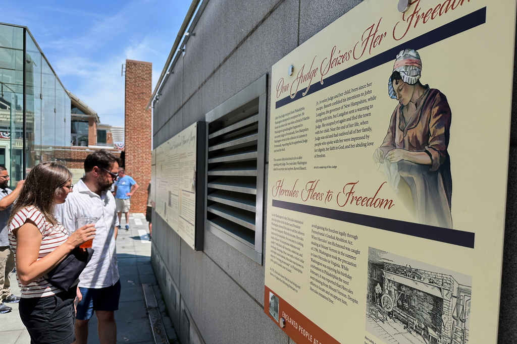 Visitors view the reinstalled educational panels about slavery at the site of President George Washington's home in Philadelphia, Wednesday, July 15, 2026. (AP Photo/Tassanee Vejpongsa)