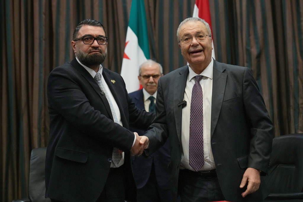 Lebanese Deputy Prime Minister Tarek Mitri, right, and Syrian Justice Minister Mazhar al‑Wais, shakes hands after they signed an agreement for the transfer of Syrian prisoners currently in Lebanese prisons to Syria, in Beirut, Lebanon, Friday, Feb. 6, 2026. (AP Photo/Hussein Malla)