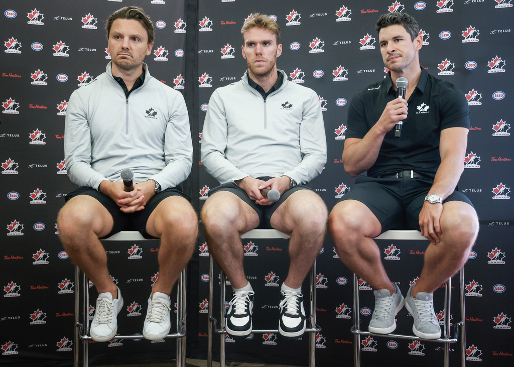 FILE - Team Canada hockey players, left to right, Sam Reinhart, Connor McDavid and Sidney Crosby speak to the media at Hockey Canada's National Teams orientation camp in Calgary, Alberta, Wednesday, Aug. 27, 2025. (Jeff McIntosh/The Canadian Press via AP, File)