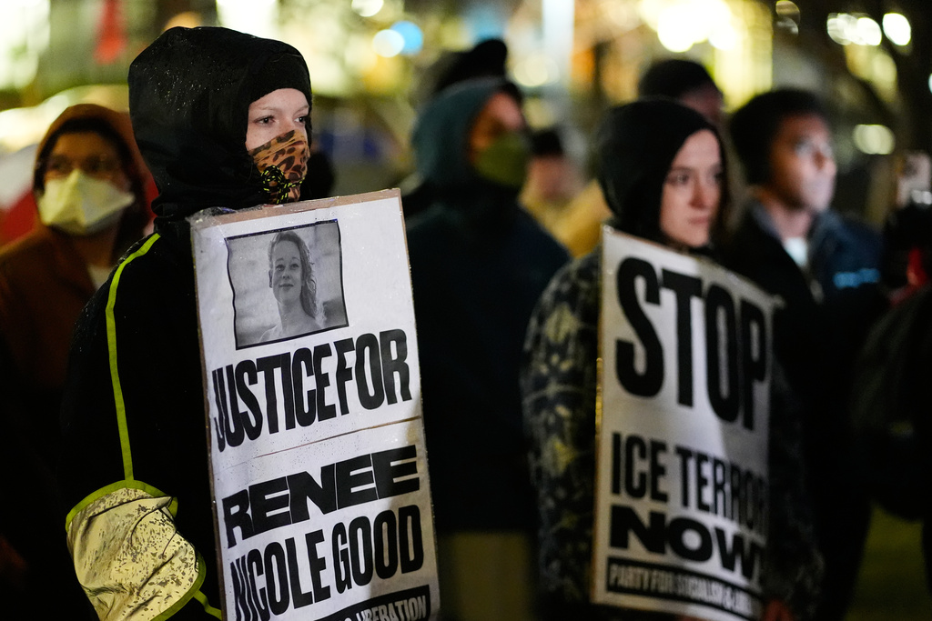 Anna Donigan, left, stands with other protesters during a rally for Renee Good, who was fatally shot by an ICE officer in Minneapolis the day before, Thursday, Jan. 8, 2026, in Kansas City, Mo. (AP Photo/Charlie Riedel)