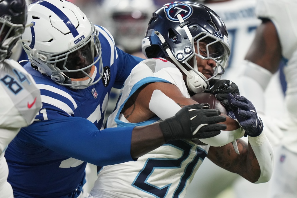 Tennessee Titans running back Tony Pollard (20) is tackled by Indianapolis Colts defensive end Kwity Paye (51) during the first half an NFL football game, Sunday, Oct. 26, 2025, in Indianapolis. (AP Photo/AJ Mast)