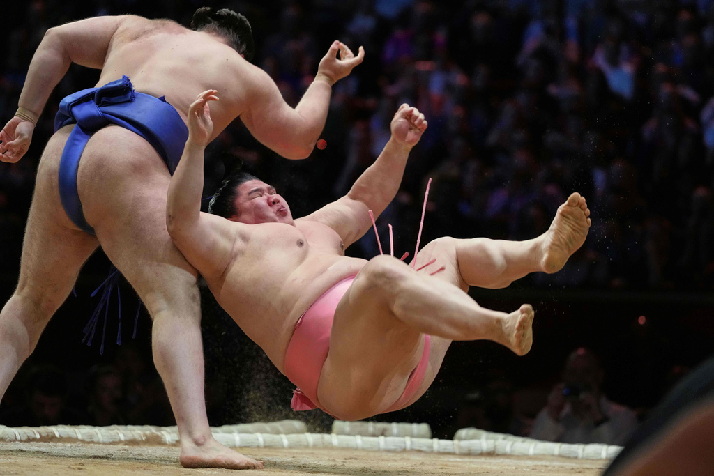Sumo rikishi Aonishiki left, and Ura during their Grand Sumo Tournament bout on the dohyo, the sacred sumo wrestling ring, at the Royal Albert Hall in London, Sunday, Oct. 19, 2025.(AP Photo/Frank Augstein)