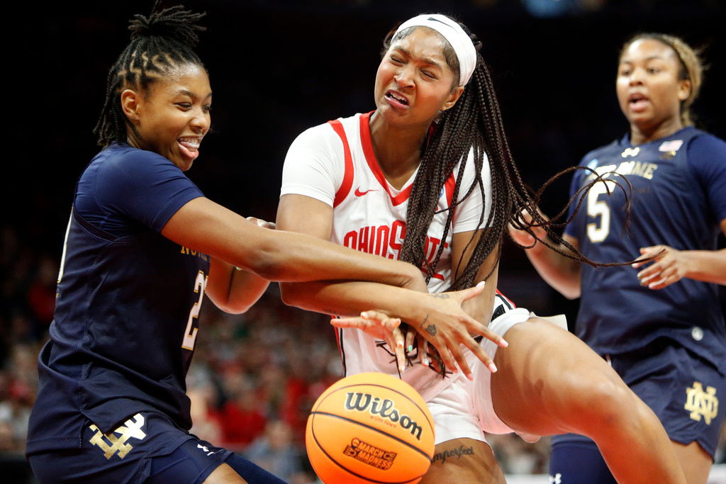 Ohio State guard Chance Gray, center, is fouled by Notre Dame guard Iyana Moore (23) as she drives in for a shot during the first half in the second round of the NCAA college basketball tournament, Monday, March 23, 2026, in Columbus, Ohio. (AP Photo/Tom E. Puskar)