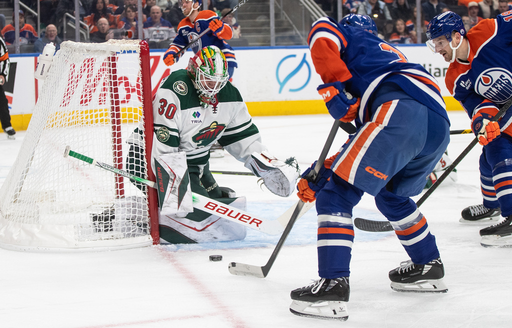 Minnesota Wild' Jesper Wallstedt (30) makes the save on Edmonton Oilers' Curtis Lazar (20) during second period NHL action, in Edmonton on Tuesday, Dec. 2, 2025. (Jason Franson/The Canadian Press via AP)