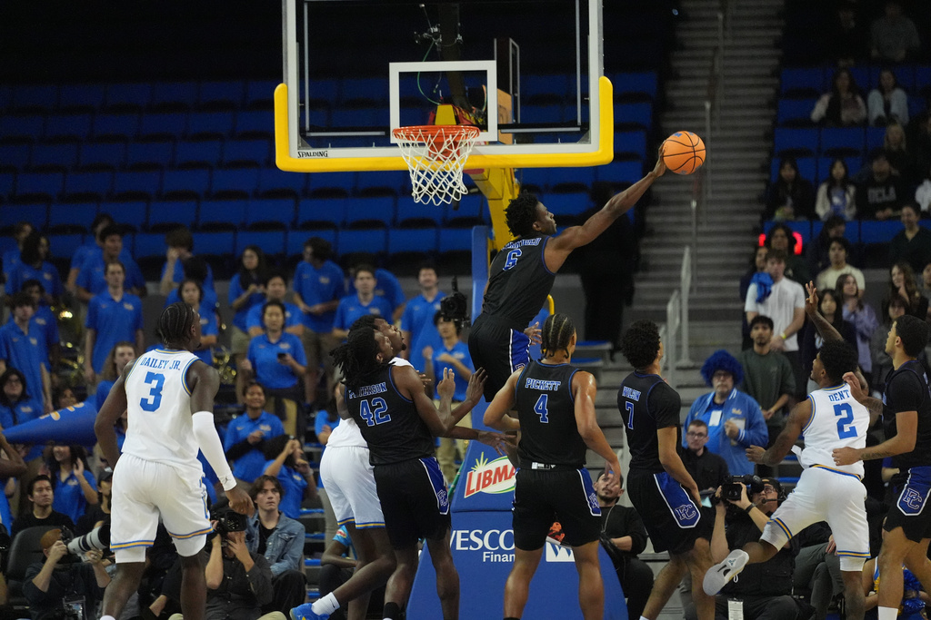 Presbyterian forward Chidi Chiakwelu (6) block a shot by UCLA guard Donovan Dent (2) during the first half of an NCAA college basketball game in Los Angeles, Friday, Nov. 21, 2025. (AP Photo/Damian Dovarganes)