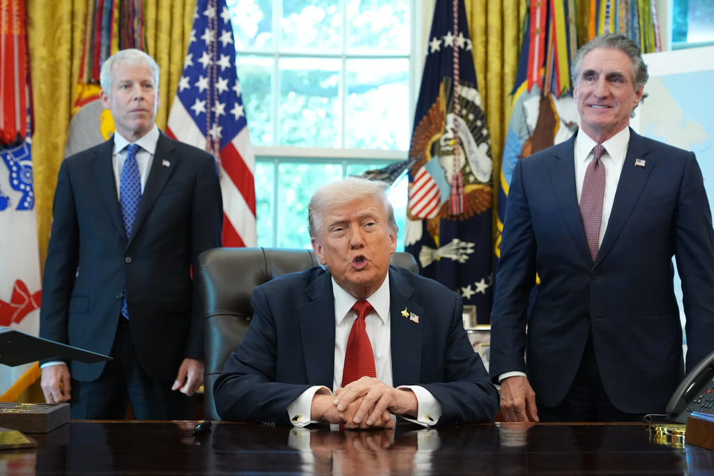 President Donald Trump speaks to reporters before signing an executive order in the Oval Office at the White House, Monday, Oct. 6, 2025, in Washington, as Energy Secretary Chris Wright and Interior Secretary Doug Burgum listen. (AP Photo/Jacquelyn Martin)