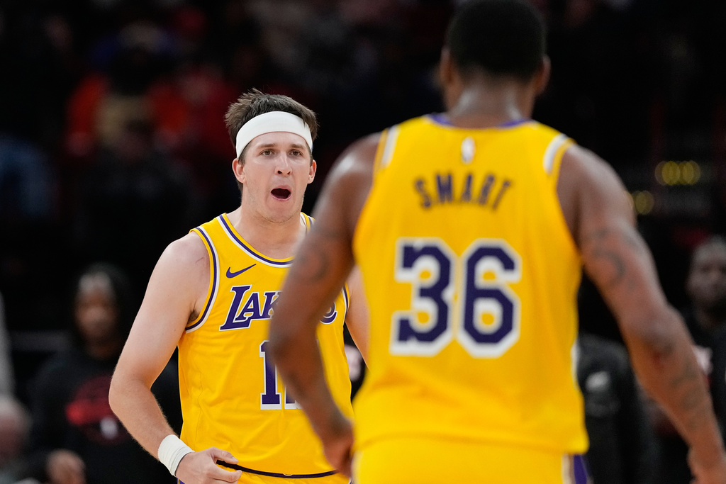 Los Angeles Lakers' Austin Reaves, left, celebrates with Marcus Smart (36) during the second half of an NBA basketball game against the Houston Rockets Monday, March 16, 2026, in Houston. (AP Photo/David J. Phillip)