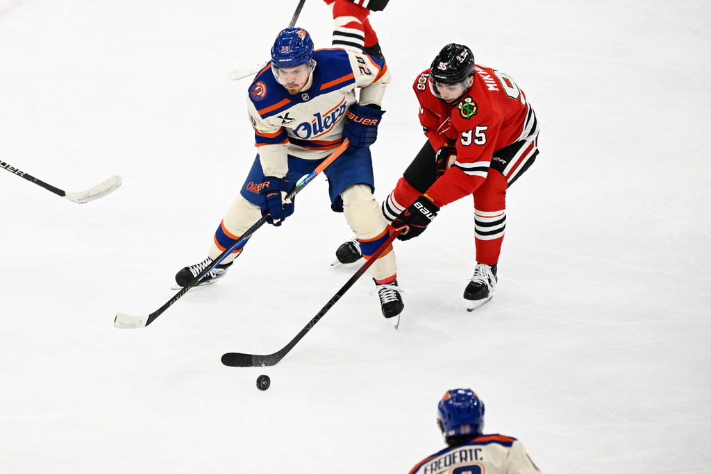 Chicago Blackhawks right wing Ilya Mikheyev (95) moves the puck against Edmonton Oilers center Jack Roslovic (28) during the second period of an NHL hockey game, Monday, Jan. 12, 2026, in Chicago. (AP Photo/Matt Marton)