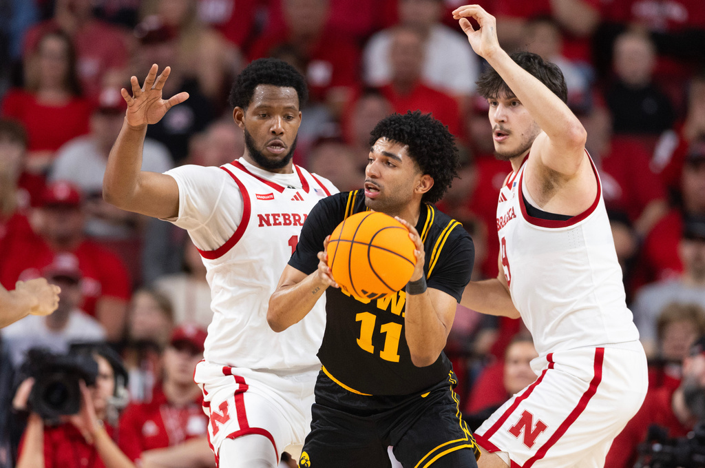 Nebraska's Jared Garcia, left, and Berke Büyüktuncel, right, guard against Iowa's Kael Combs during the first half of an NCAA college basketball game, Sunday, March 8, 2026, in Lincoln, Neb. (AP Photo/Rebecca S. Gratz)