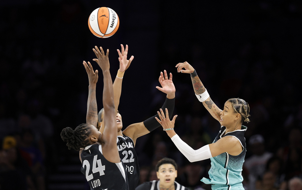 New York Liberty guard Natasha Cloud passes over Las Vegas Aces guard Jewell Loyd (24) and center A'ja Wilson (22) during the first half of a WNBA basketball game, Wednesday, Aug. 13, 2025, in Las Vegas. (Steve Marcus/Las Vegas Sun via AP)