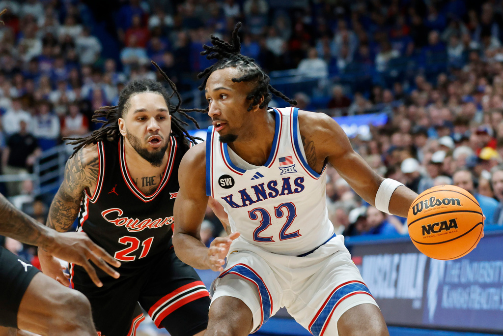 Kansas guard Darryn Peterson (22) attempts to get past Houston guard Emanuel Sharp (21) during the first half of an NCAA college basketball game Monday, Feb. 23, 2026, in Lawrence, Kan. (AP Photo/Colin E. Braley)