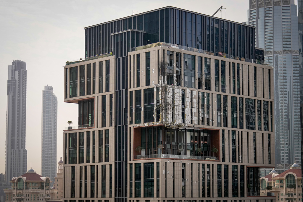 Facade of a building at Dubai's financial district is seen partially damaged which, according to the authorities was caused by falling debris after a successful interception, United Arab Emirates, Friday, March 13, 2026. (AP Photo/Altaf Qadri)