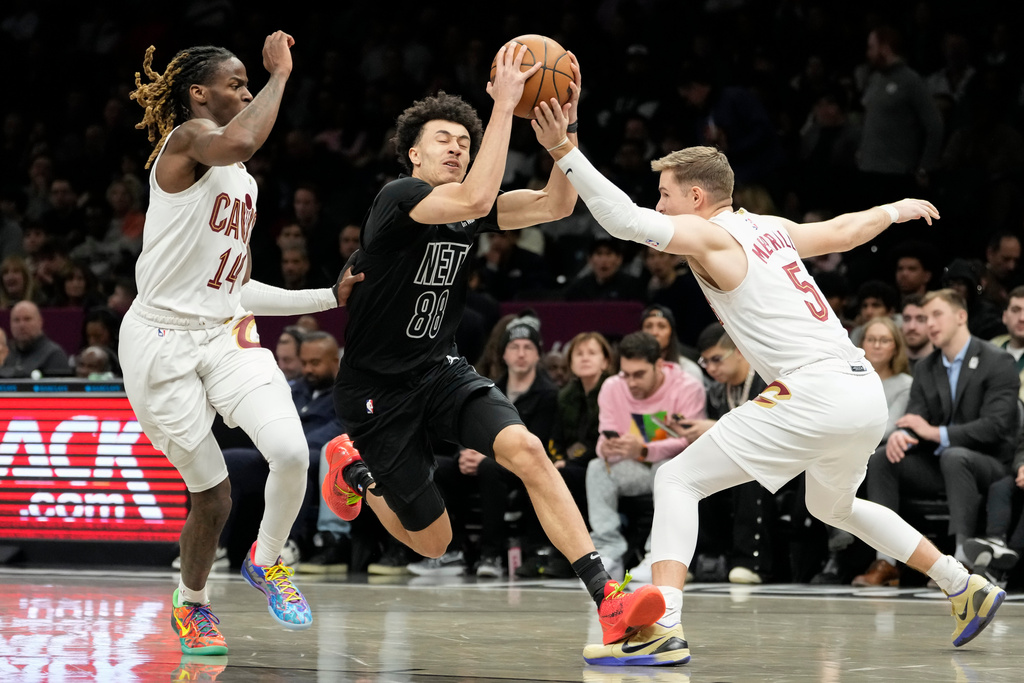 Brooklyn Nets guard Nolan Traore (88) drives past Cleveland Cavaliers guard Sam Merrill (5) and Cleveland Cavaliers guard Keon Ellis (14) during the first half of an NBA basketball game, Sunday, March 1, 2026, in New York. (AP Photo/Yuki Iwamura)
