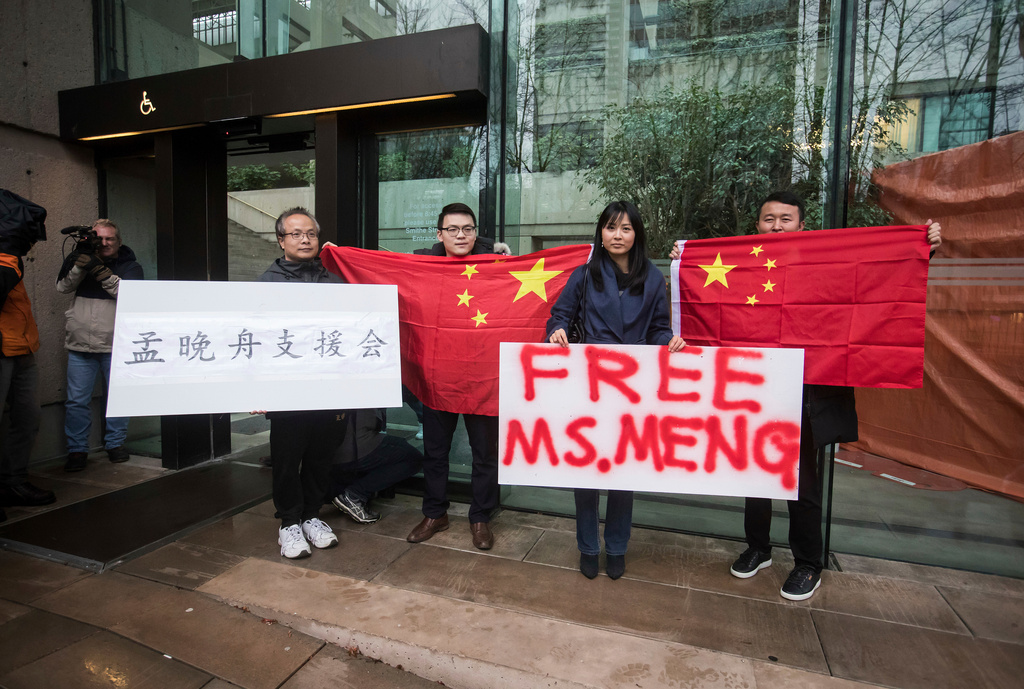 FILE - Supporters hold signs and Chinese flags outside British Columbia Supreme Court during the third day of a bail hearing for Meng Wanzhou, the chief financial officer of Huawei Technologies, in Vancouver, on Tuesday December 11, 2018. (Darryl Dyck/The Canadian Press via AP, File)