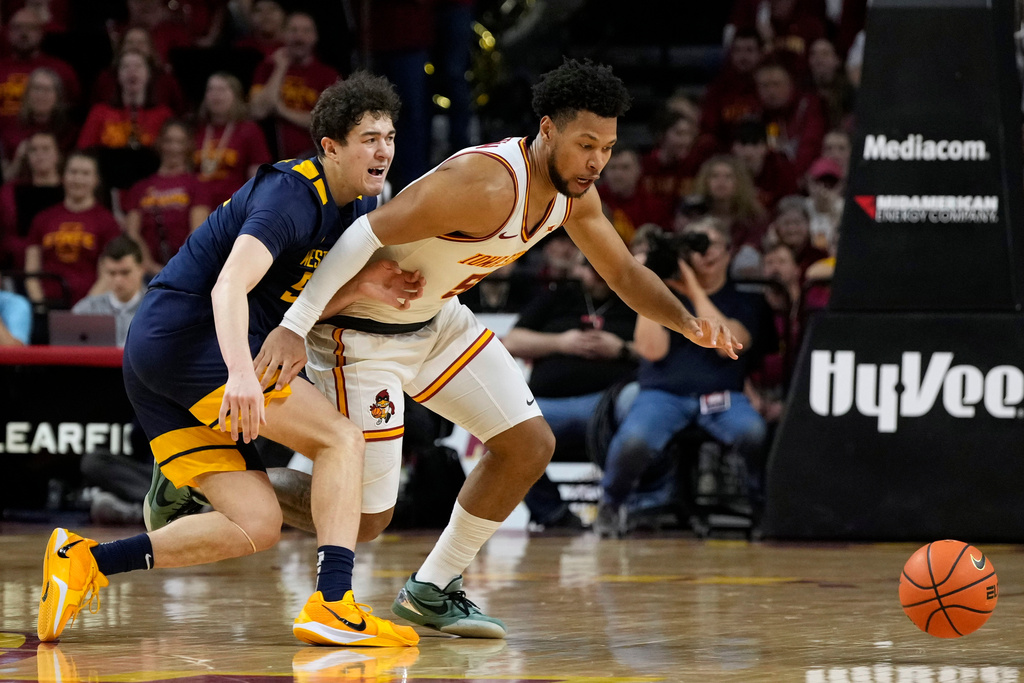 West Virginia guard Treysen Eaglestaff, left, fights for a loose ball with Iowa State forward Joshua Jefferson during the second half of an NCAA college basketball game, Friday, Jan. 2, 2026, in Ames, Iowa. (AP Photo/Charlie Neibergall)