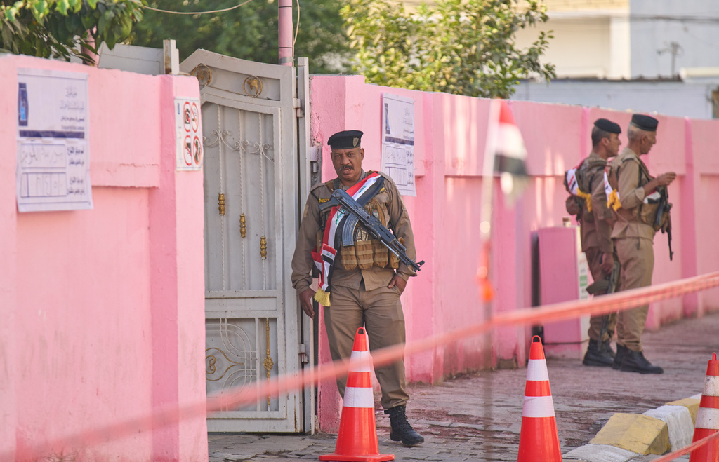 Security forces stand guard outside a polling station during a special voting session ahead of Tuesday's parliamentary election in Baghdad, Iraq, Sunday, Nov. 9, 2025. (AP Photo/Hadi Mizban)