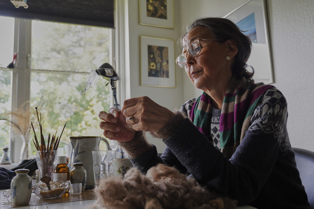 66-year-old retiree Kirstine Berthelsen prepares wool for sewing at her home in northern Copenhagen, Denmark, Sept. 17, 2025. (AP Photo/James Brooks)