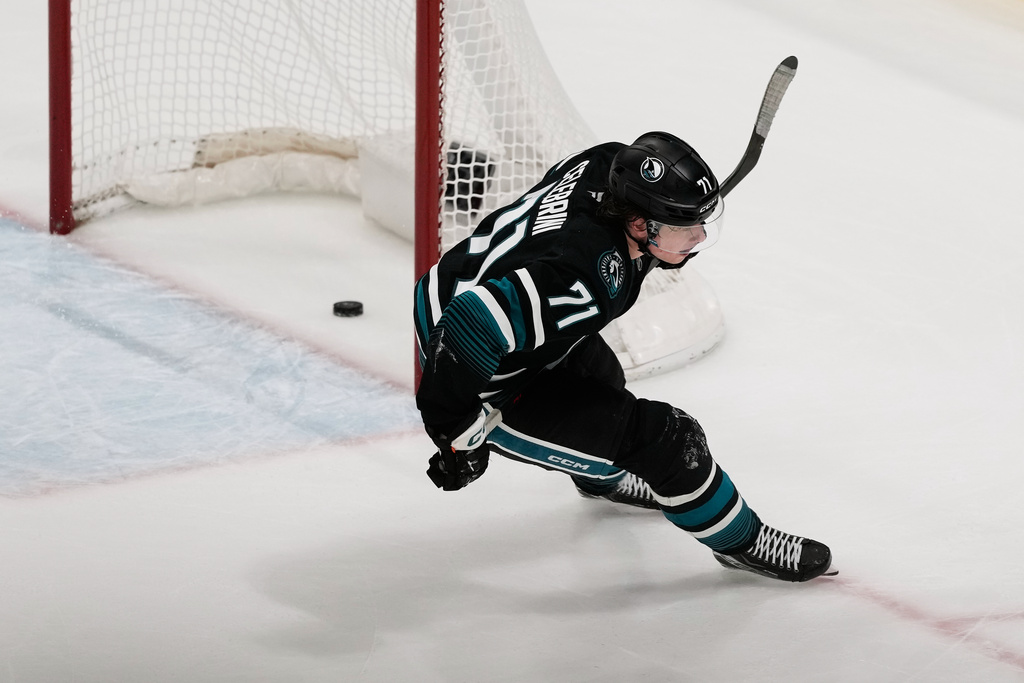 San Jose Sharks center Macklin Celebrini scores an empty net goal during the third period of an NHL hockey game against the Calgary Flames in San Jose, Calif., Tuesday, Dec. 16, 2025. (AP Photo/Jeff Chiu)