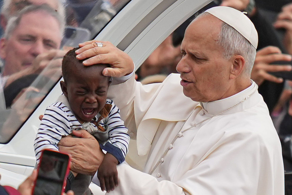FILE - Pope Leo XIV blesses a child at the end of a Mass for the Jubilee of Migrants and Missionaries in St. Peter's Square at the Vatican, Oct. 5, 2025. (AP Photo/Alessandra Tarantino, File)