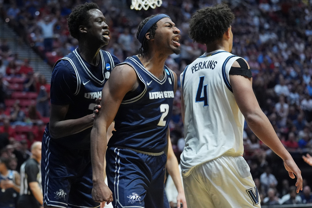 Utah State guard MJ Collins (2) and forward Adlan Elamin, left, celebrate next to Villanova guard Tyler Perkins (4) during the second half in the first round of the NCAA college basketball tournament, Friday, March 20, 2026, in San Diego. (AP Photo/Marcio Jose Sanchez)