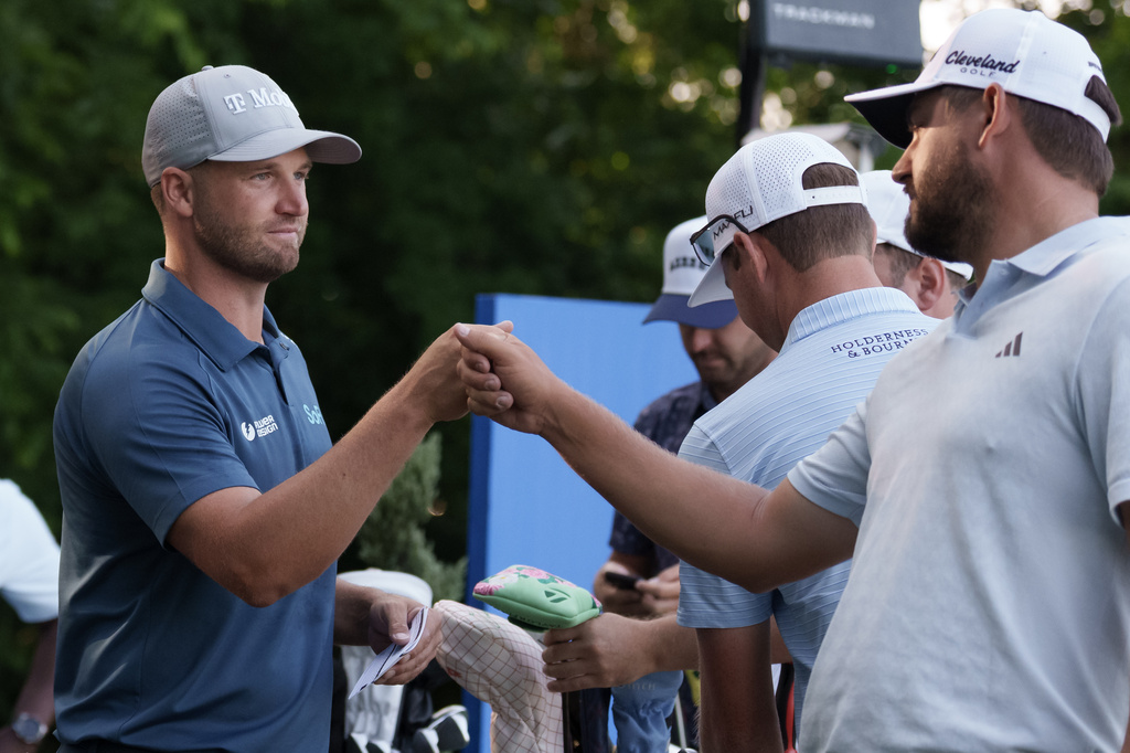 Zurich defending champion Andrew Novak, right, fist bumps Wyndham Clark before they tee off on the 10th hole to start the first round of the PGA Zurich Classic golf tournament at TPC Louisiana, Thursday, April 23, 2026, in Avondale, La. Novak is playing with Ben Griffin and Clark with Taylor Moore. (AP Photo/Matthew Hinton)