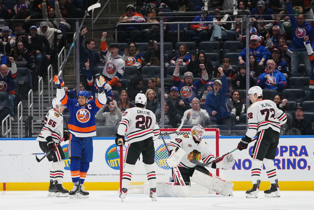New York Islanders' Anders Lee, left, celebrates after scoring a goal as Chicago Blackhawks goaltender Arvid Soderblom, Ryan Greene (20) and Alex Vlasic (72) react during the first period of an NHL hockey game Tuesday, March 24, 2026, in Elmont, N.Y. (AP Photo/Frank Franklin II)