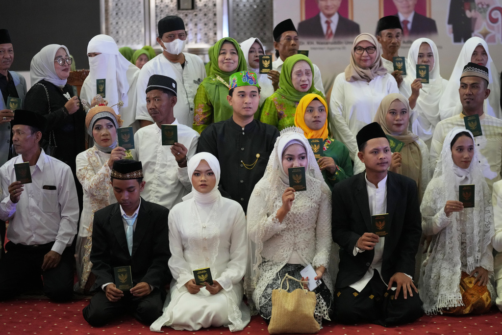 Brides and grooms pose for a group photo after a mass wedding ceremony at Istiqlal Mosque in Jakarta, Indonesia, Wednesday, Dec. 3, 2025. (AP Photo/Tatan Syuflana)