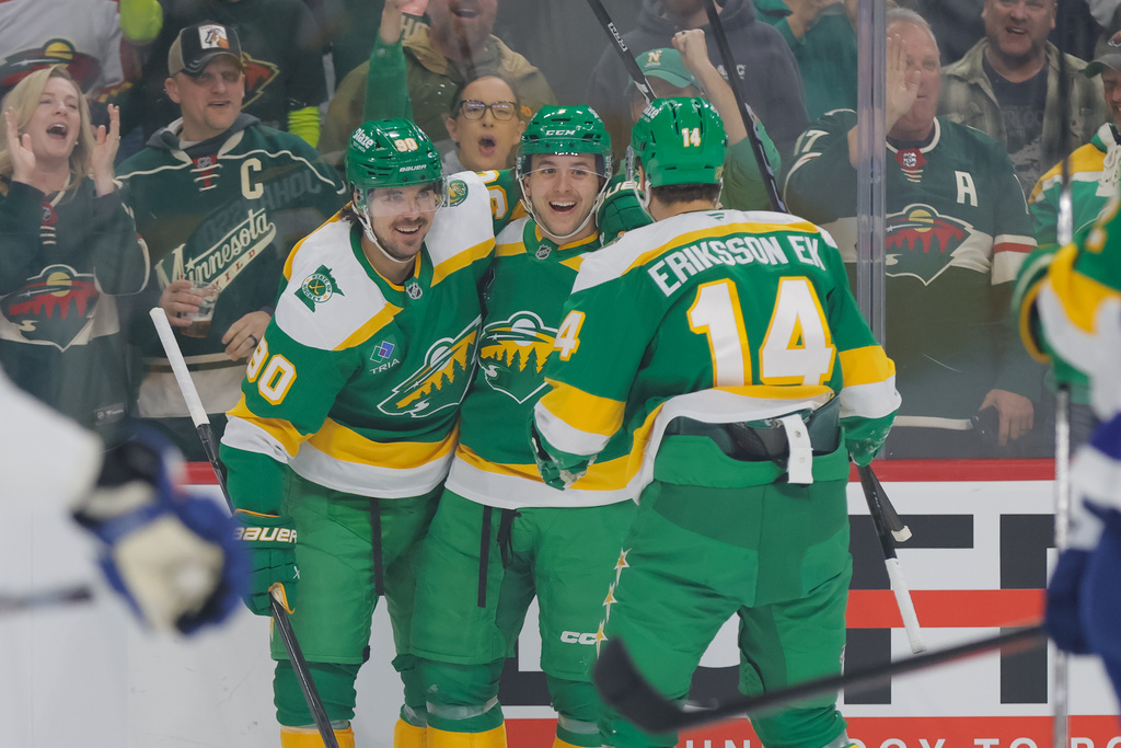 Minnesota Wild defenseman Brock Faber (7) celebrates with left wing Marcus Johansson (90) and center Joel Eriksson Ek (14) after scoring during the first period of an NHL hockey game against the Tampa Bay Lightning, Tuesday, March 3, 2026, in St. Paul, Minn. (AP Photo/Bailey Hillesheim)