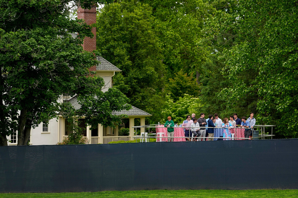 Fans watch from outside the fence line along the first fairway during the second round of the PGA Championship golf tournament at Aronimink Golf Club, Friday, May 15, 2026, in Newtown Square, PA. (AP Photo/Carolyn Kaster)