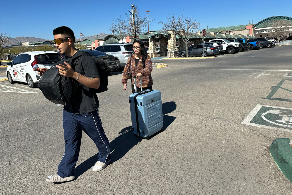 Jorge Rueda, 20, and Yamilexi Meza, 21, who arrived from Las Cruces, N.M., walk through a parking lot at El Paso International Airport in El Paso, Texas, on Wednesday, Feb. 11, 2026. (AP Photo/Morgan Lee)