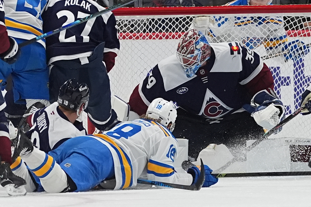 Colorado Avalanche goaltender MacKenzie Blackwood, right, stops a shot by St. Louis Blues center Robert Thomas, front right, as Colorado center Jack Drury defends in the first period of an NHL hockey game Sunday, April 5, 2026, in Denver. (AP Photo/David Zalubowski)