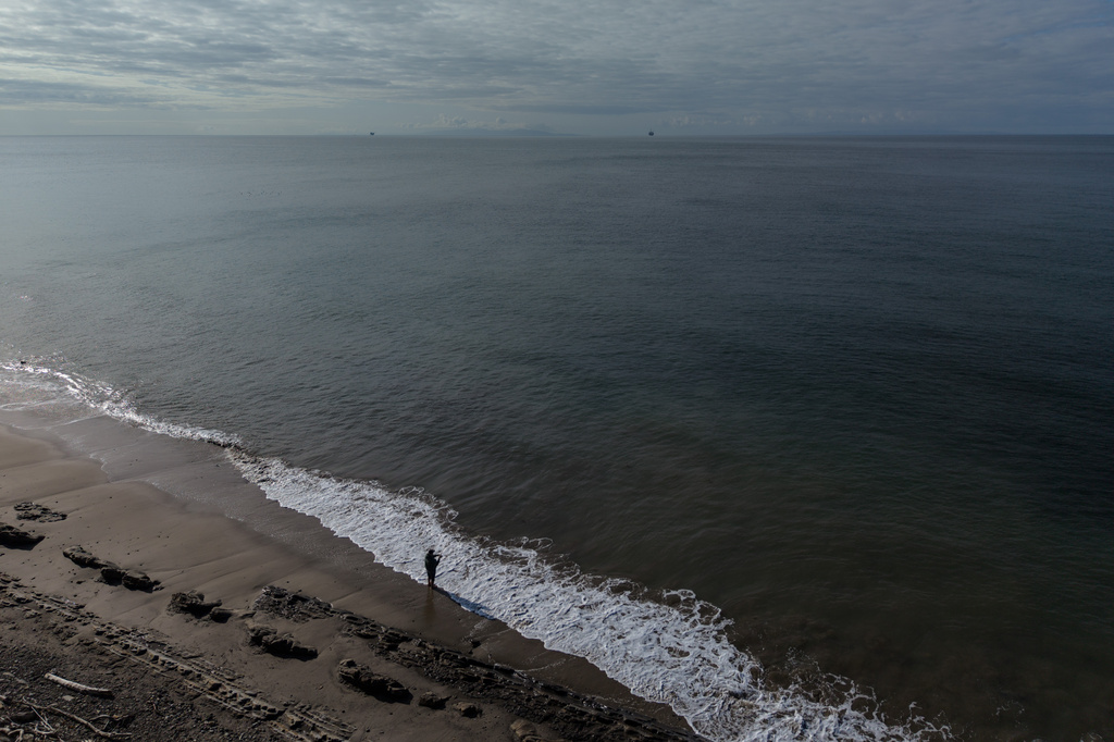 A person casts a fishing line into the ocean at Gaviota State Park in Santa Barbara County, Calif., Sunday, April 26, 2026, as an offshore drilling platform operated by Sable Offshore Corp. is seen in the distance. (AP Photo/Jae C. Hong)