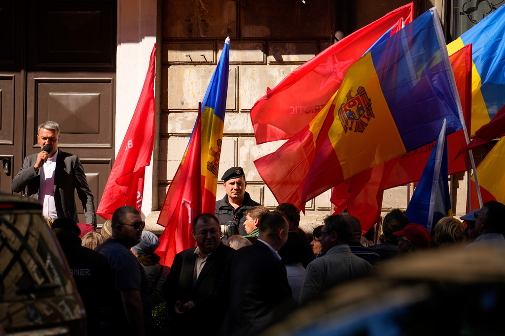 A gendarme watches as supporters hold flags at a protest rally of the Russia-friendly Patriotic Electoral Bloc in Chisinau, Moldova, Friday, Sept. 26, 2025, ahead of parliamentary elections taking place on Sept. 28. (AP Photo/Vadim Ghirda)