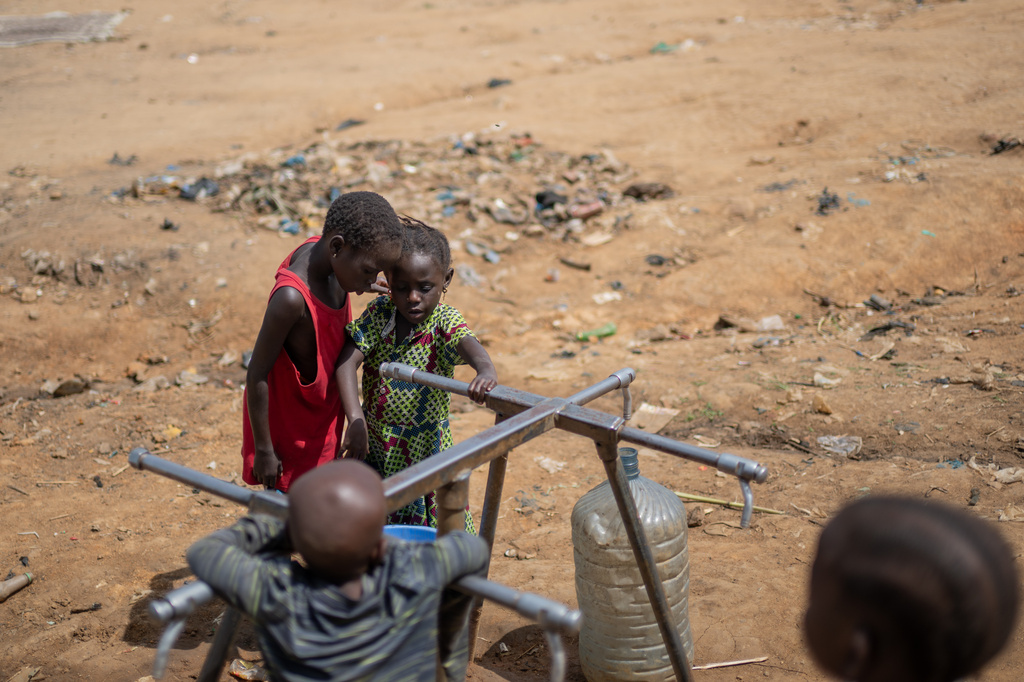 Internally displaced children play with a broken water pump at the camp on the property of the city's ISP (Institut Supérieur Pédagogique) in Bunia, Congo, Tuesday, May 26, 2026. (AP Photo/Moses Sawasawa)